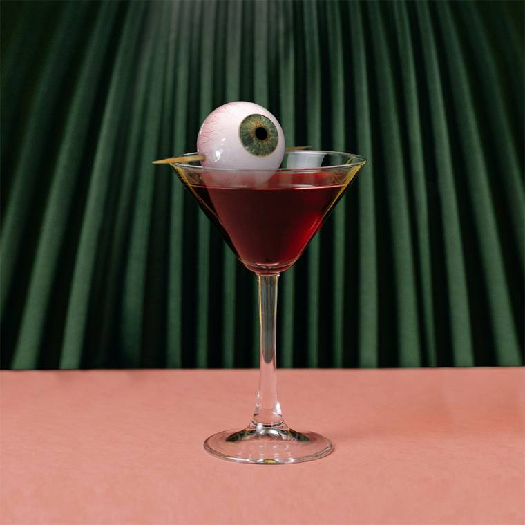 Illustration presenting a martini glass with an eyeball on a toothpick